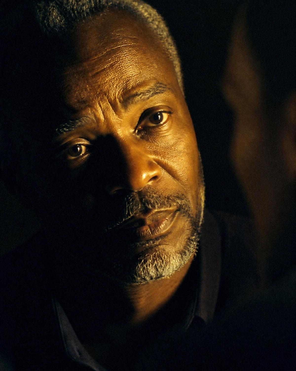 Close portrait of a man listening, lit by warm gold light